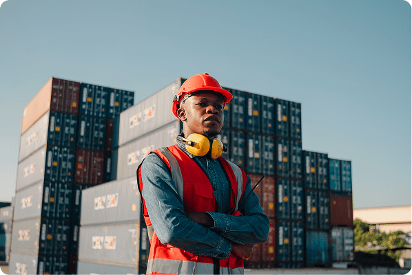 Black construction worker with shipping containers